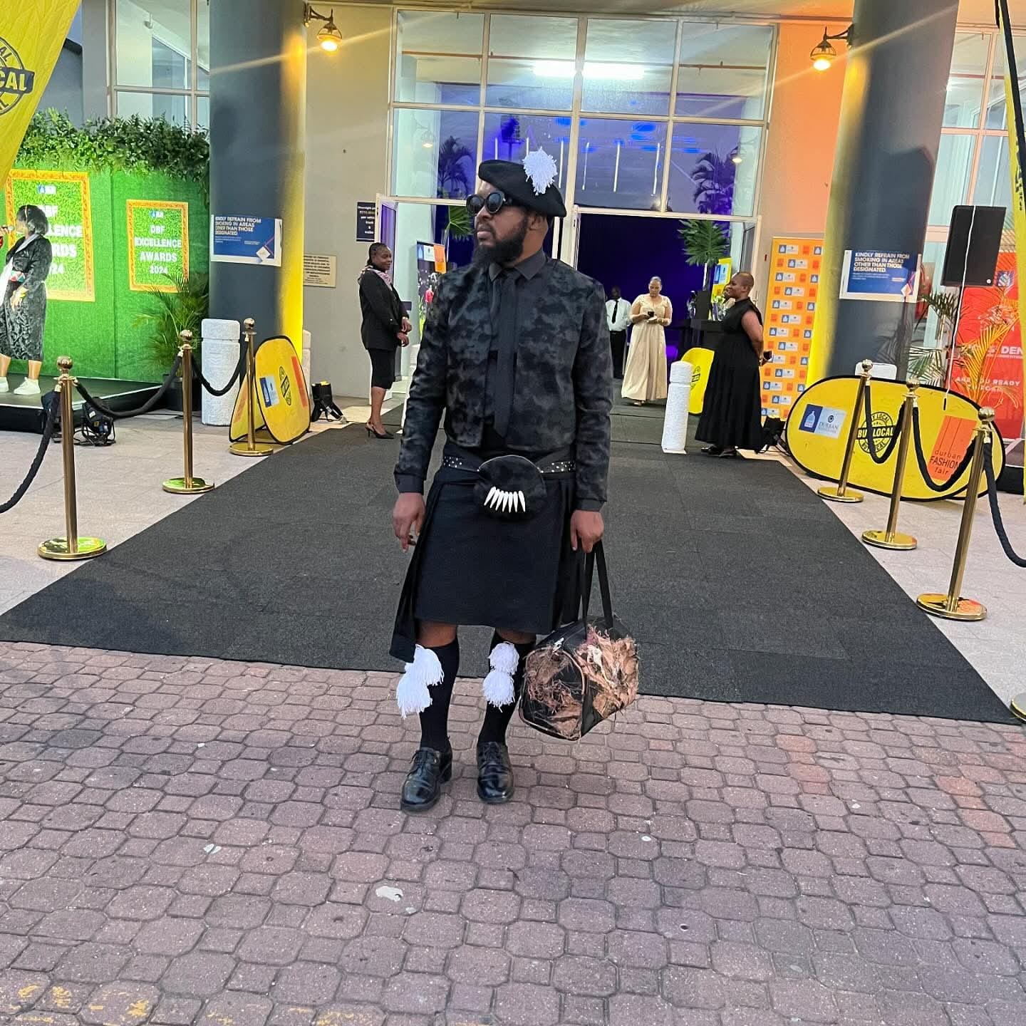 Mkhathini Mlotshwa wearing an expressive dark tailored ensemble